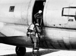 Chinese soldiers climb down ladder out of C-46 transport plane. During WWII.