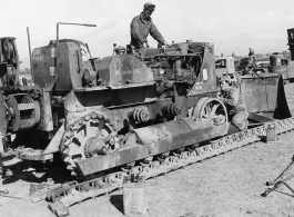 Shown working on D7 Bulldozer at Tengchong BRE Camp, after it was brought over the Hump, are L to R, Pvt. William Guthrie, and T/4 Curtiss R. Greenwood.  Photo by T/Sgt. Greenberg.  Passed by censor Emanuel Goldberg.