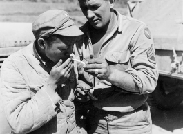 At the Tengchong cutoff: Convoy driver S/Sgt. Michale P. Havery, is shown lighting up cigarette of a Chinese soldier.  Yunnan Province on March 4, 1945.  Photo by T/Sgt. Greenberg.  Passed by William E. Whitten.