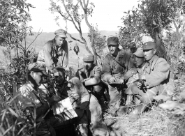 American liaison officers and Chinese troop commanders plan coordinated air and ground attack on Japanese forces at Hung Chiu Hill, southwest of Chefang.  L-R: Capt. Benjamin C. Adams, Earl M. Rothberger, Capt. William L. Yeomans (F. A. Liaison O), Col. Wang Ching-shan (C.O. 389th Reg.), Lt. Col. J.N. Ruggieri (Liaison O. With 130th Division), Wang Chen-yuan (Interpreter), and Maj. Gen. Wang Li-huan (C.G. 130th Div., 53rd Chinese Army).  Yunnan Province on November 30, 1944.   Photo by T/5 W. E. Shemorry. B