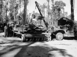 GIs load cut lumber at saw mill in Burma for transport to sites of bridge building.  During WWII.  797th Engineer Forestry Company.