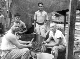 Engineers of the 797th Engineer Forestry Company skin potatoes in KP duty at a camp in Burma. During WWII.