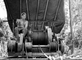 GI pulls logs with donkey engine in Burma.  797th Engineer Forestry Company in Burma.  During WWII.