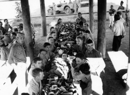 Engineers of the 797th Engineer Forestry Company eating fancy meal in Burma, possibly in the stilt space under a private home.  During WWII.