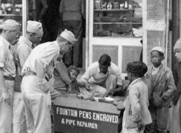 GIs of the 2005th Ordnance Maintenance Company, 28th Air Depot Group, at engraver stand, possibly in Barrackpore, India.