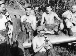 The boys hanging out on remains of fighter plane.  Leo Spearence (with pipe) in center, John Schuhart (far right).  Likely in Burma. 2005th Ordnance Maintenance Company,  28th Air Depot Group.