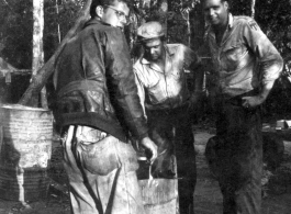 Grease-covered men of the 2005th Ordnance Maintenance Company, 28th Air Depot Group, warming up at burn barrel in Burma. During WWII.