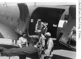 Selig Seidler plays patient being loaded into or out of a C-47 transport in a publicity movie:"During filming for nurses publicity move. Acting as stretcher case, S. Seidler, feeling fine."