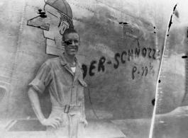 Flyer Walter Wegner poses with B-24 "DER-SCHNOZZE" in this highly damaged image. 10th Air Force, 7th Bombardment Group.  During WWII.