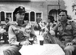 Dave Hayward and Jim Hamer drink "Vimto" (British soft drink) at a sidewalk cafe in Agra. 22nd Bombardment Squadron, during WWII.