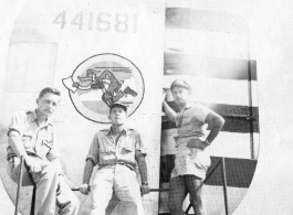 American flyers with tail assembly of a F-7A/B-24, showing The Wily Wolves insignia. October 4, 1945, Gushkara, India.  Lt. Willhoite, Lt. W. J. Rumler, Lt. "Mike" Howes.  24th Combat Mapping Squadron, 8th Photo Reconnaissance Group, 10th Air Force.
