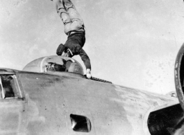 American flyer does a handstand on the two .05 cal guns of a turret on a F-7A/B-24.  24th Combat Mapping Squadron, 8th Photo Reconnaissance Group, 10th Air Force.