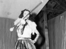 Baton twirling a USO show in Gushkara, India, during WWII.  The boxes in front of the band players are labeled 748th ROB (748th Railway Operating Battalion).
