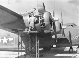 Engine maintenance F-7A/B-24 "The FLYING ANVIL." At Chanyi (Zhanyi), China.  Note the engineer getting a few minutes of rest on the concrete, in the shade below the wing.  24th Combat Mapping Squadron, 8th Photo Reconnaissance Group, 10th Air Force.