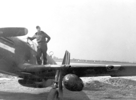 A flyer with a P-51 Mustang fighter, probably at an American air base in China. During WWII.  This appears to be Ernest W. Garner.