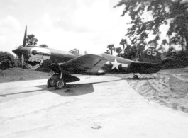 P-40 fighter #65, probably tail #2105234, of the 80th Fighter Group, the “Burma Banshees,” on pavement at an airbase in in Burma during WWII.