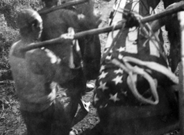 Chinese laborers carrying an American war dead draped in US flag. Near Tengchong, Yunnan, China. Williams notes that he had given blood donation for this soldier, but he had still not survived.  From the collection of Kenneth Williams.