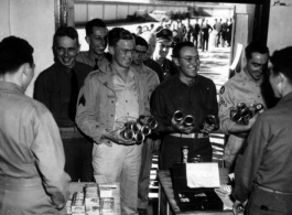 Happy servicemen receiving beer and cigarettes in the CBI.