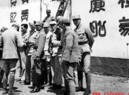 Americans and Chinese in the CBI in front of wall covered in propaganda. During WWII.
