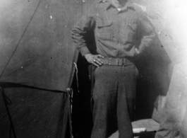 Rex B. Gouger, member of the 76th Fighter Squadron, 23rd Fighter Group, poses in front of a tent in the CBI during WWII.