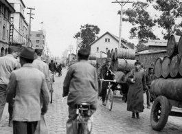 A street scene in either Songming  or Kunming, in Yunnan province, China, during WWII. Notice the 55-gallon barrels being hauled away for reuse after flying over The Hump.  From the collection of Eugene T. Wozniak.