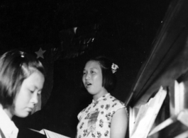 During WWII, as part of an appreciation activity for the American Army Air Force, a Chinese school girl sings while another plays piano.