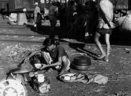 September 27, 1944  During WWII, a refugee from the Japanese Ichigo drive on Kweilin (Guilin) prepares her evening meal in the station at Liuchow, China.