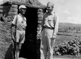 20-28 August 1944  Capt. George D. McGrath, 8266 Fountain Ave., Los Angeles, Calif., Burma Road Engineers, chats with a Chinese guard outside the guard\'s mud and straw shelter, during WWII.  Photo by Pvt. B. E. Einson