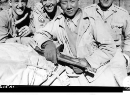 American and Chinese soldiers--drivers of the first truck convoy to China in almost three years smile happily as they reach the China border at Wanting.  The dusty, begrimed drivers took turns with their Allies in driving over the 1,004-mile route form Ledo, India, to Kunming, China. During WWII.   (OWI-PW staff photo by Sgt. John Gutman)