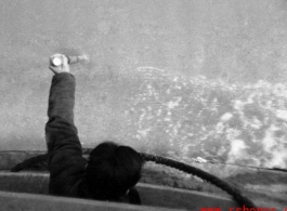 Man uses pole to check water depth in northern China during WWII, probably on the Yellow River.