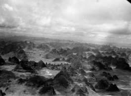 "Kweilin in aerial photo (land of a thousand breasts)."  Flying over distinct karst formations in Guangxi province, near Guilin (Kweilin), in China during WWII.