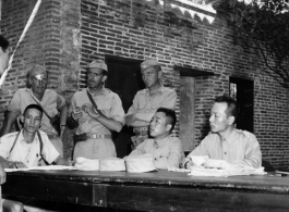 A Chinese prisoner being interrogated by the Chinese and Americans during WWII.