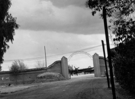 The gate of an airbase in Yunnan province, China, with a C-46 transport showing. During WWII.