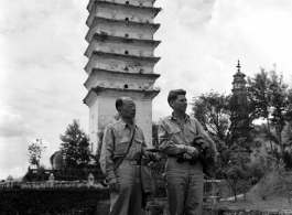 Two American servicemen in SW China area standing in front of pagoda.  Note that the one on the left is a chaplain.