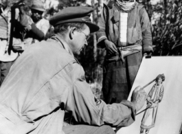 U. S. Combat Artist, Sgt. R. Zounes, draws a Lisu woman along the Burma Road, during WWII.