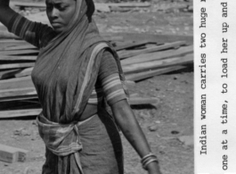 An Indian woman carries two huge rocks on her head at a construction site. During WWII.  Photo from Delbert Wood.