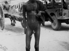 A nude man on the street in India during WWII.