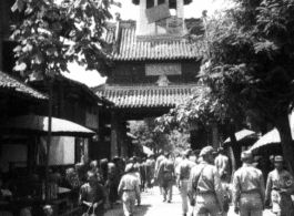 Drum or bell tower at the center of Kiunglai, with busy market street nearby, a shopping spot for GIs. During WWII.  Photo from C. W. Miller.