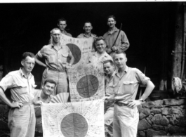 Y Force liaison team shows of captured Japanese Good-Luck Flags  (寄せ書き日の丸) collected on the battleground in the CBI during WWII. 1944.  Photo by Cpl. Hedge.