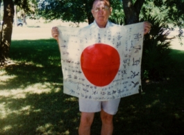 George Pollock shows off trophy captured Japanese Good-Luck Flag  (寄せ書き日の丸) collected on the battleground in the CBI during WWII.