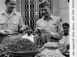 Bob Lichty (left) and John Darnell, both "sporting Indian caps," check out a nut vendor's stock in Bombay, India, during WWII.  Photo from Bob Lichty.