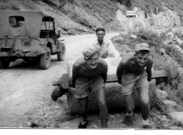 Three GIs stop to move roller out of the way... or pretend to for the camera. In the CBI during WWII.