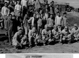 Members of air freight crew, both GIS and local people, in China during WWII.   Front row: Cpl. Stanko, Sgt. V. A. Green, Sgt. Gorer, Pfc. Bartko, Pvt. Spears.  Background on truck: Pvt. Firestone.  Official U.S. Gov image.