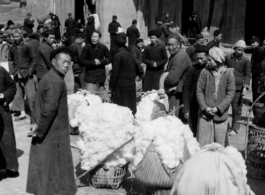 Cotton buyers and sellers in Xi'an (Hsian) in 1943 negotiate their trades.