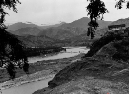 A river valley in SW China, either Yunnan or Sichuan, during WWII, with a pedestrian rope bridge across the river.  Photo from Dorothy Yuen Leuba.
