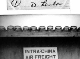 Sgt. Lewis, 12th Air Service Group, standing at a door labeled "Intra-China Air Freight" at Peishiyi, 1945.   Photo from Dorothy Yuen Leuba.