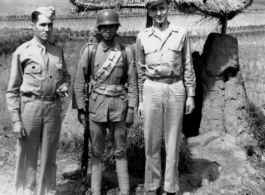 Two GIs (M. J. Hollman and Chaplain J. Kelly) pose with a chinese guard in SW China during WWII.