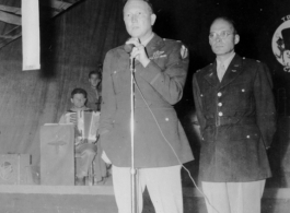 A GI holds the microphone as musicians wait, in the CBI during WWII. 322nd Troop Carrier.