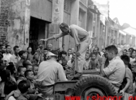 Capt. Grove campaigning for himself for mayor in a small town we passed through. Croughan on left, Capt. Penick on right.  Near an American base in Guangxi province (either Guilin or Liuzhou), China, during WWII.