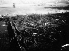 Smoke arises from city wall after attack by B-25 Mitchell bombers during battle with Japanese ground forces, flying over Tengchung (Tengchong), near the China-Burma border in far SW China.